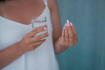 Sick female taking medicines, antidepressant, painkiller or antibiotic. Young lady drinking contraceptives. Pharmacy and healthcare concept