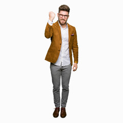 Fototapeta premium Young handsome business man wearing glasses angry and mad raising fist frustrated and furious while shouting with anger. Rage and aggressive concept.