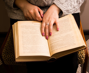 Naklejka premium hand of a woman on old book