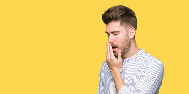 Young handsome man bored yawning tired covering mouth with hand. Restless and sleepiness.