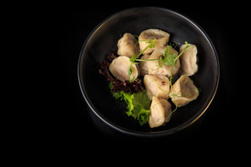 top view of boiled meat dumplings with salad in deep bowl