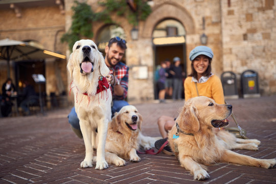 Happy Man And Woman With Dog Laughing And Having Fun On Vacation..