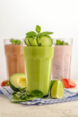 Bright green and pink smoothie in a tall glass.