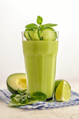 Bright green smoothie in a high glass.