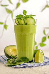 Bright green smoothie in a high glass.