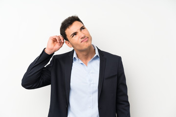 Handsome man over isolated white wall having doubts and with confuse face expression