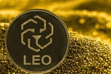 Coin cryptocurrency Leo bitfinex token on golden background.