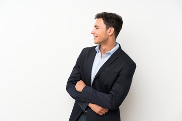 Handsome man over isolated white wall looking to the side