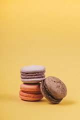 Close up colorful set of macaron on yellow background. Traditional french dessert. Sweet delicious food