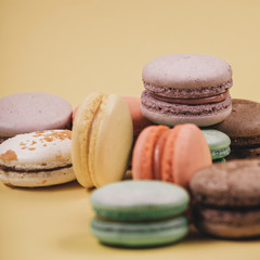 Close up colorful set of macaron on yellow background. Traditional french dessert. Sweet delicious food