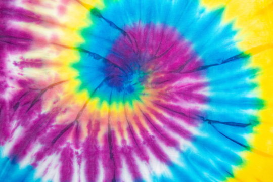 Tie Dye spiral vibrant and gradient rainbow multicolor , hippie shirt pattern . abstract fabric texture and background .