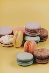 Top view of set macaron on soft yellow paper background. Traditional french dessert. Delicious food