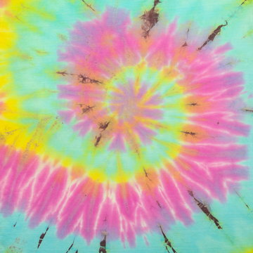 Tie Dye spiral vibrant and gradient rainbow multicolor , hippie shirt pattern . abstract fabric texture and background . minimal mood and tone cloth .