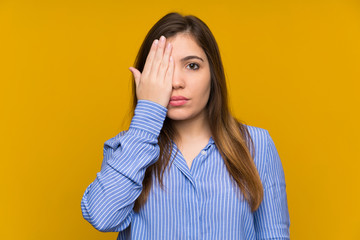 Young girl with striped shirt covering a eye by hand