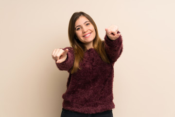 Young girl points finger at you while smiling