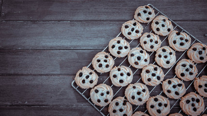 Butter cookies are decorated with freshly baked raisins from the oven, placed on a stainless steel grill And put on the old wooden floor.