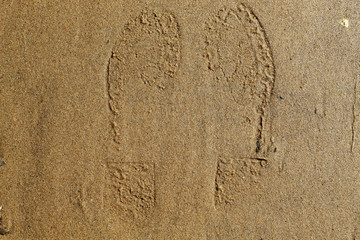 Footprints of a man on the sand near the city river