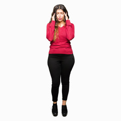 Fototapeta premium Young beautiful woman wearing red sweater with hand on head for pain in head because stress. Suffering migraine.