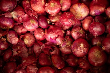 red onion pile in market .