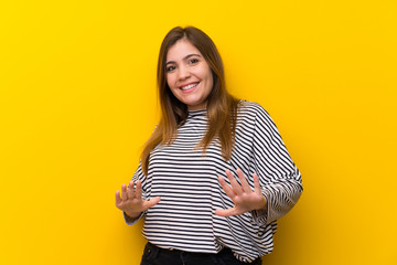 Young girl over yellow wall smiling