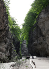 Chegem gorge in Kabardino-Balkaria in the North Caucasus, Russia. View of the rough mountain river and the collapsing road between the cliffs