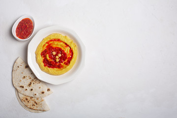Obraz na płótnie Canvas Hummus on a plate. Chickpea dish prepared with harissa sauce