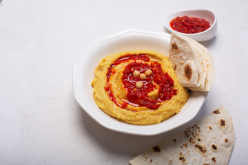 Hummus on a plate. Chickpea dish prepared with harissa sauce