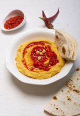 Hummus on a plate. Chickpea dish prepared with harissa sauce