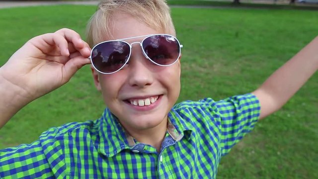 Closeup view portrait of cute funny young kid teasing and laughing and making funny faces into camera.