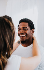 Happy Biracial Couple in Modern White Room