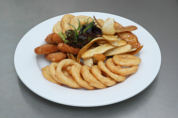 Chicken nuggets, french fries and sauce. Fried nuggets and potato with basil oak lettuce