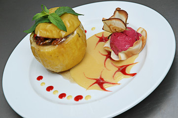 Baked apple with ice cream on a plate on a gray background