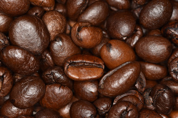 The unique texture of shiny grains of roasted coffee on fire close-up