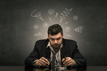 Young drunk man at his office with doodles around
