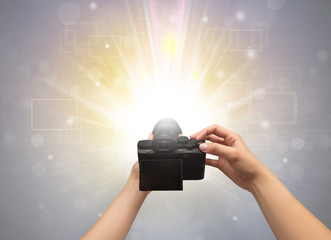 Naked hand taking picture with digital camera and glowing flash concept
