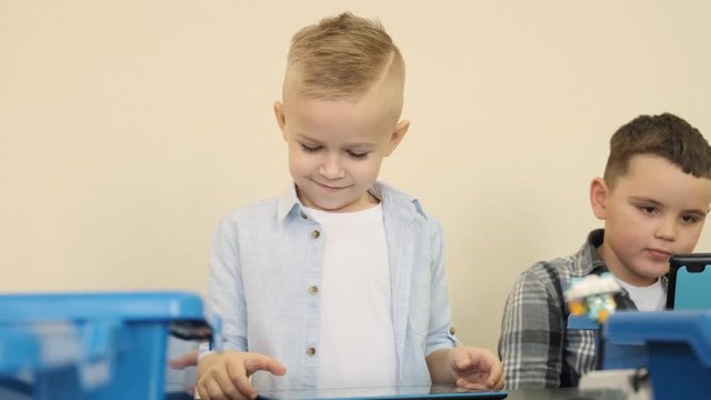 Blond and brunet boys are training their skills in control of electronic small cars slow motion