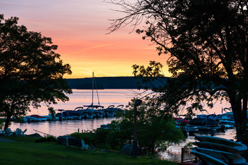 Sunset on a lake with a sailboat and marina