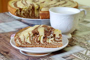 Zebra sponge cake and a Cup of milk on the table