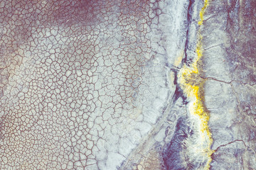 Aerial view of surrealistic industrial place. Dry surface. Desertic landscape. Human impact on the environment. View from above. Abstract industrial background.