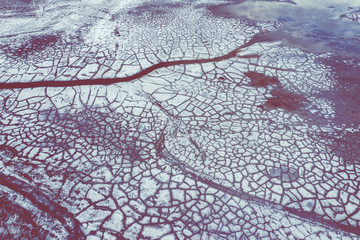 Aerial view of surrealistic industrial place. Dry surface. Desertic landscape. Human impact on the environment. View from above. Abstract industrial background.