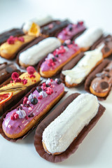 Set of several eclairs with various fillings and design isolate on a white background, the concept of French cuisine