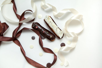 Close-up of a set of two eclairs with different fillings and design isolate on a white surface...