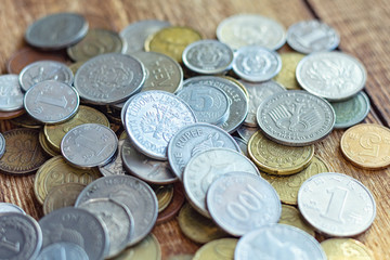 coins old rusty brass euro Seychelles Bulgaria China Germany pile pack heap stack on a wooden background finance economy investment savings concept mock up selective focus close up