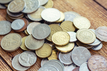 coins old rusty brass euro Seychelles Bulgaria China Germany pile pack heap stack on a wooden background finance economy investment savings concept mock up selective focus close up