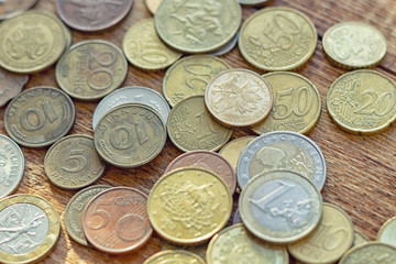 coins old rusty brass euro Seychelles Bulgaria China Germany pile pack heap stack on a wooden background finance economy investment savings concept mock up selective focus close up