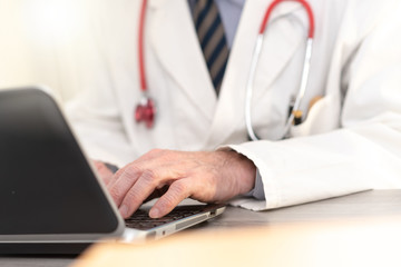 Male doctor using laptop