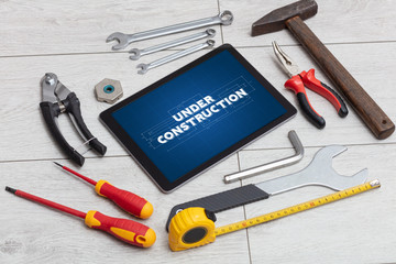 Tablet and tools with home under construction concept
