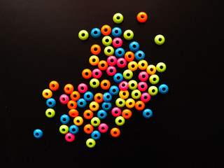 multicolored plastic beads on a black background       