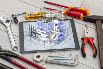Tablet with construction tools and 3d house plan concept
