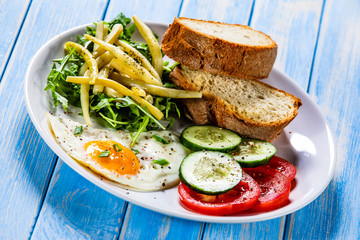 Breakfast - fried egg, toasts and vegetable salad